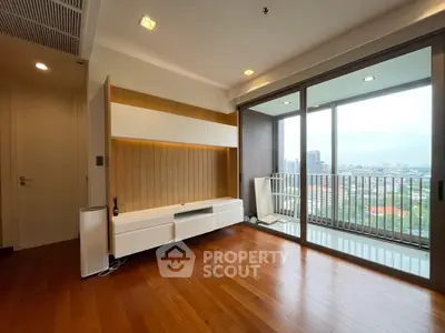 Spacious living room with wooden floors and balcony view in modern apartment