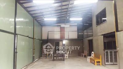 Spacious industrial-style interior with high ceilings and mezzanine level