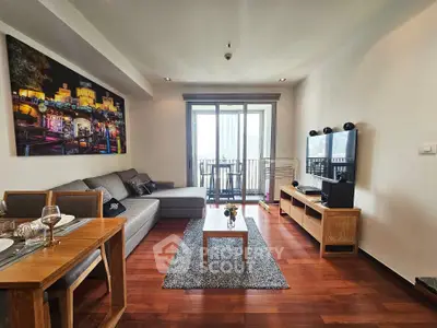 Modern living room with stylish decor and balcony view, featuring wooden flooring and contemporary furniture.