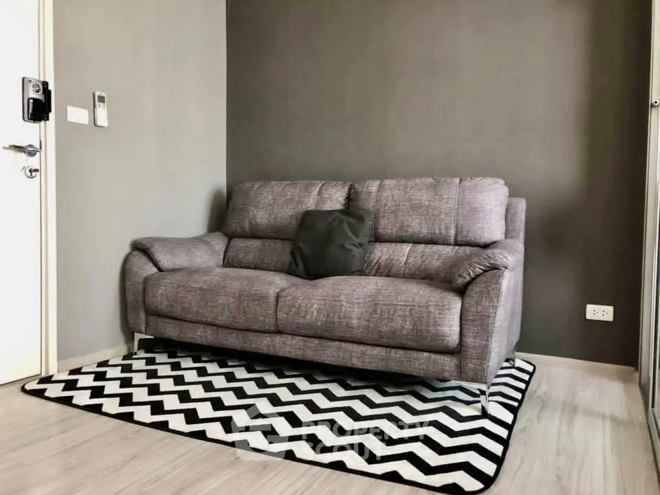 Modern living room with stylish gray sofa and chevron rug
