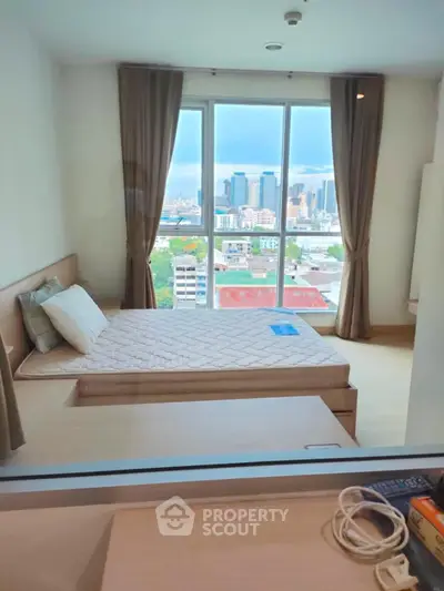 Modern bedroom with city view and large window, featuring a cozy bed and elegant curtains.