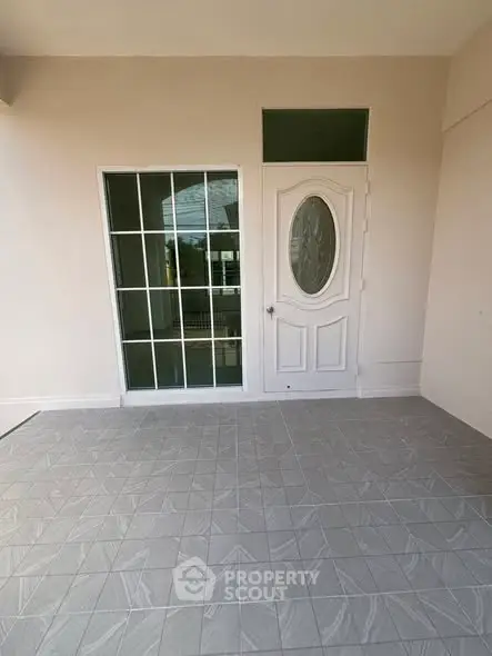 Charming entrance with elegant door and tiled flooring, perfect for welcoming guests.