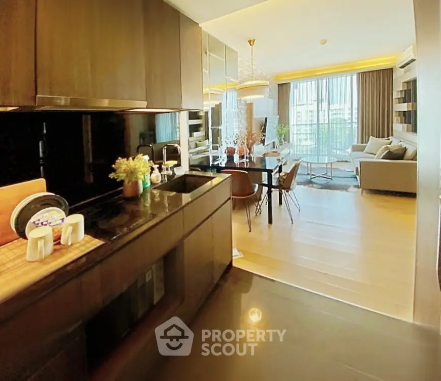 Luxurious open-layout kitchen and living room with modern decor and large windows.