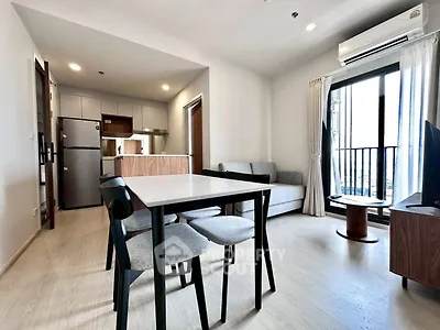 Modern open-plan living room with dining area and balcony access in a stylish apartment.