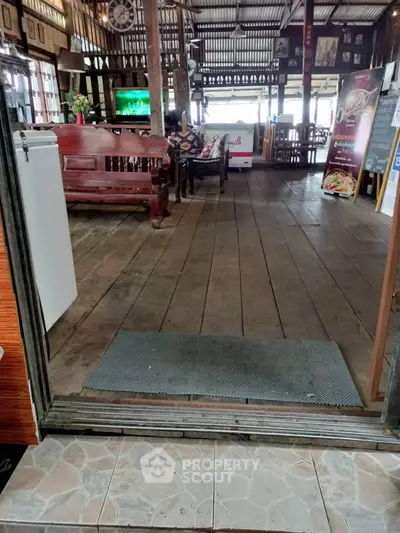 Charming rustic interior with wooden flooring and cozy seating area.