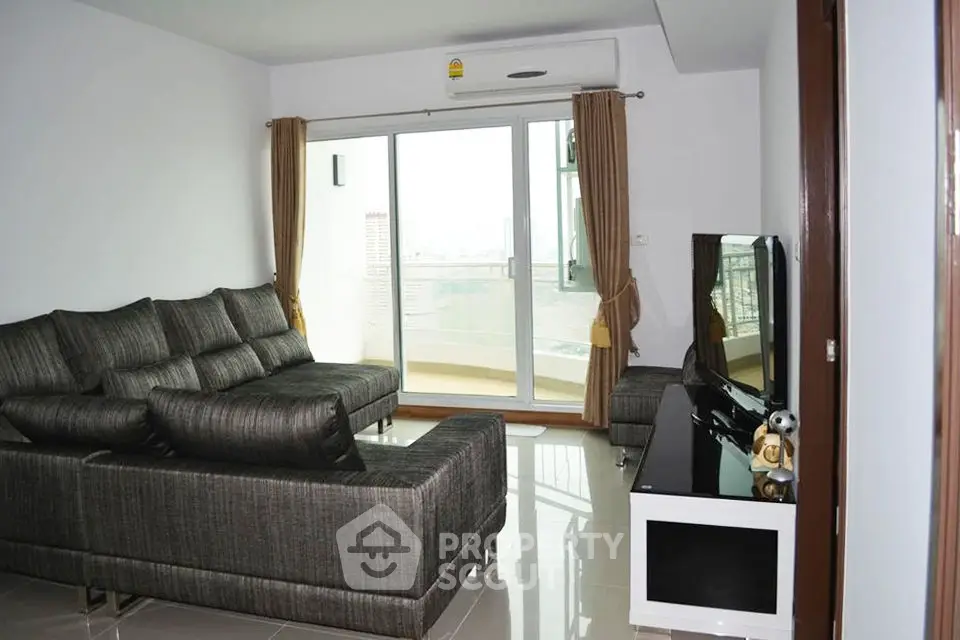 Spacious living room with modern sofa and balcony view in a stylish apartment.