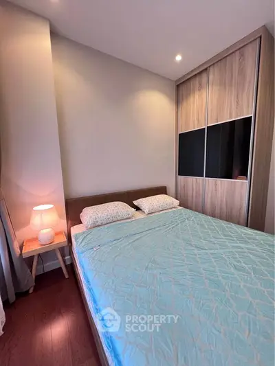 Cozy bedroom with modern wooden wardrobe and soft lighting, perfect for relaxation.