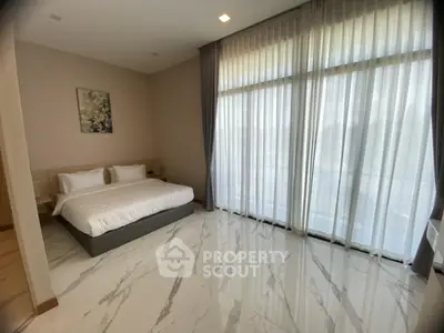 Spacious bedroom with large windows and elegant marble flooring