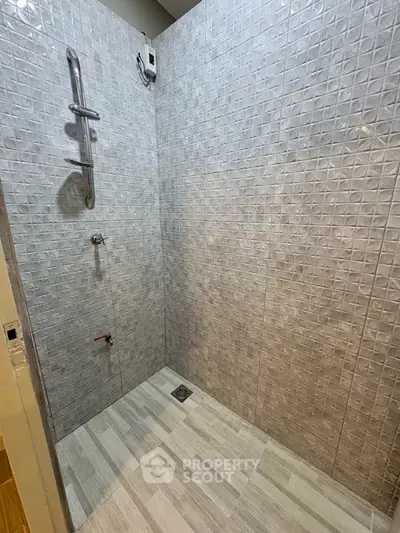 Modern bathroom with sleek tiled shower area and contemporary fixtures.