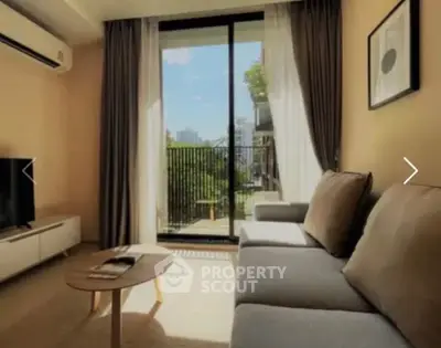 Modern living room with large window and balcony view, featuring a cozy sofa and sleek TV setup.