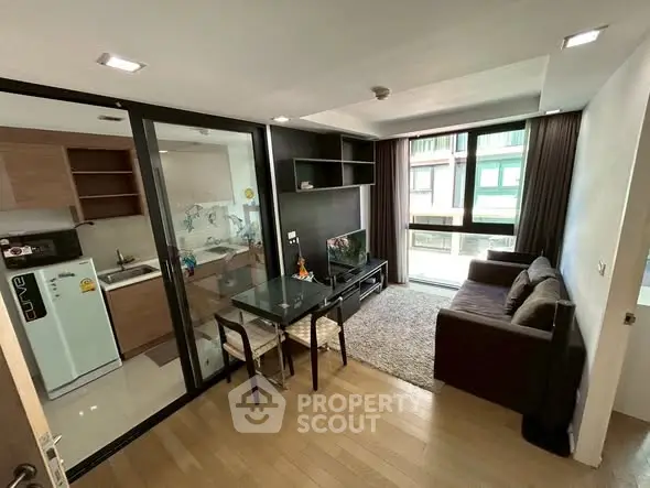 Modern living room with open kitchen and cozy seating area in stylish apartment.