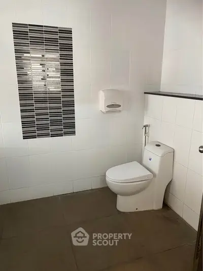 Modern bathroom with sleek toilet and stylish tile accent wall