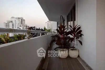 Spacious balcony with city view and potted plants in modern apartment