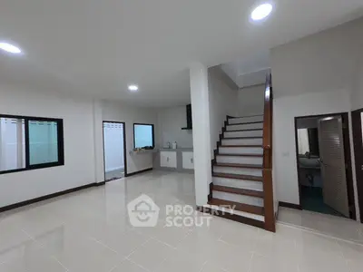 Spacious modern interior with sleek staircase and open layout kitchen.