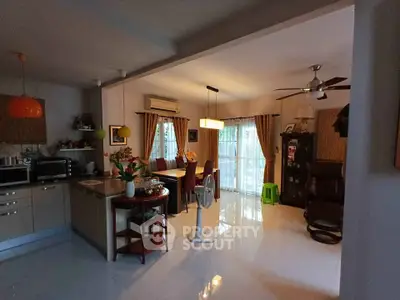 Spacious open-plan living and dining area with modern kitchen and natural light.