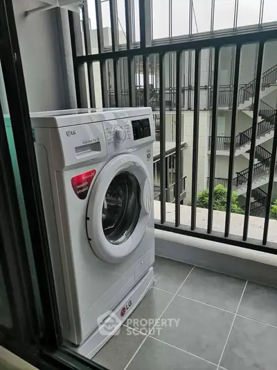 Modern balcony with washing machine and urban view, perfect for city living convenience.