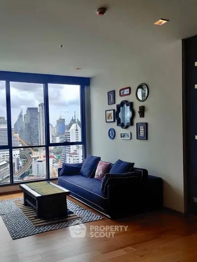 Stylish living room with city view, featuring modern decor and large windows in a high-rise apartment.