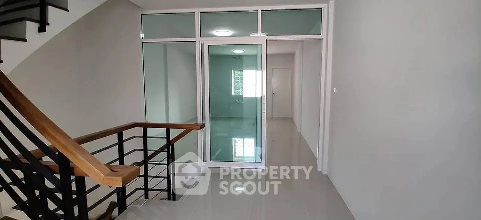 Modern townhouse interior with sleek staircase and glass partition