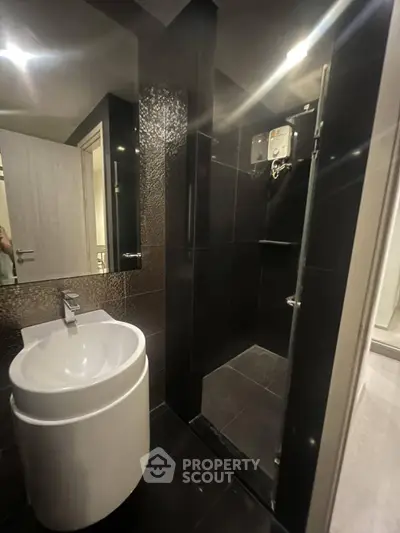 Modern bathroom with sleek black tiles and contemporary fixtures.