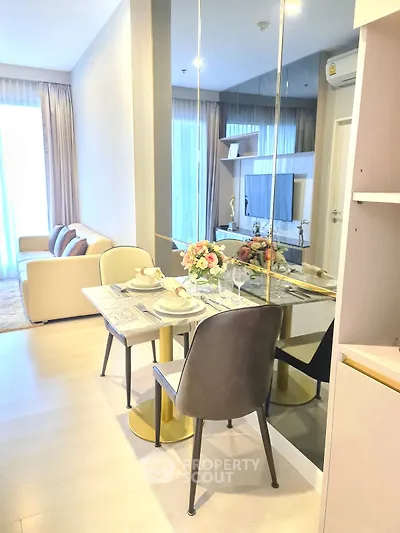 Modern living room with dining area, elegant decor, and large mirror enhancing space.