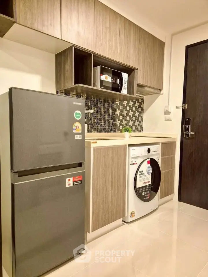 Modern kitchen with sleek appliances and stylish cabinetry in a contemporary apartment.