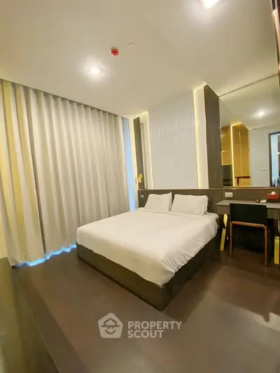 Modern bedroom with sleek design and cozy ambiance, featuring a comfortable bed and stylish furnishings.