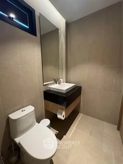 Modern bathroom with sleek fixtures and neutral tiles, perfect for a contemporary home.