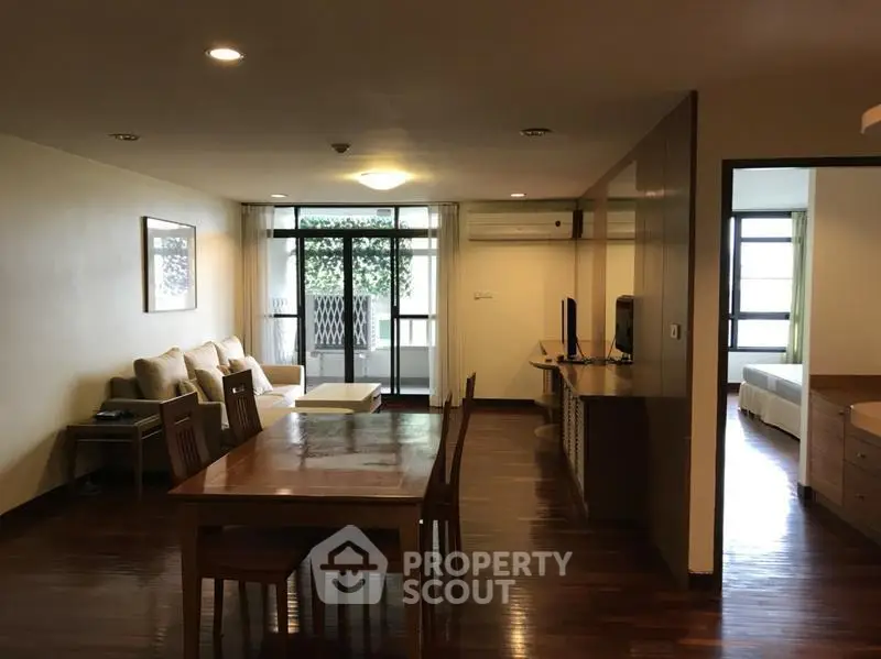 Spacious open-plan living and dining area with wooden flooring and natural light.