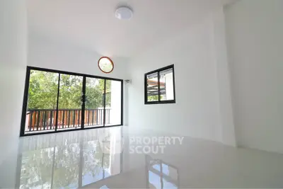 Spacious modern living room with large windows and balcony view