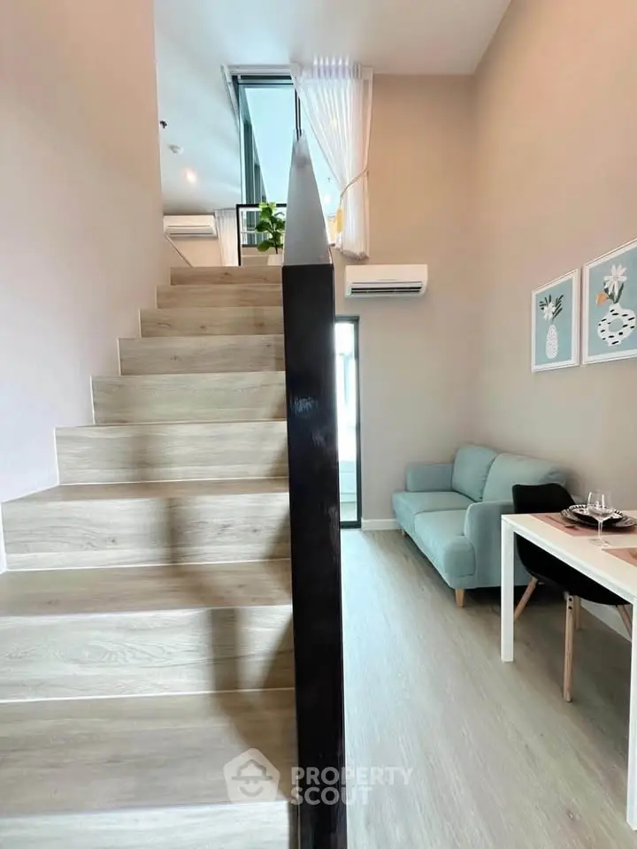 Modern duplex interior with stylish staircase and cozy living area, perfect for urban living.