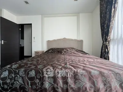 Elegant bedroom with luxurious bedding and natural light from large window