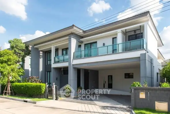 Modern two-story house with sleek design and spacious driveway in a suburban neighborhood.