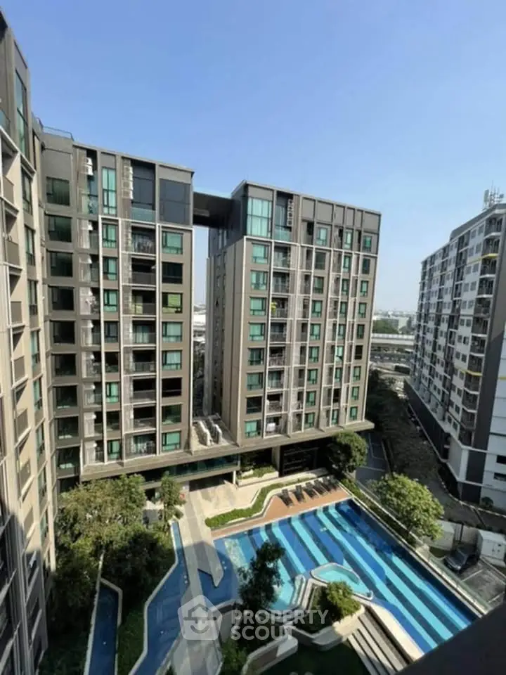 Modern apartment complex with swimming pool and lush landscaping, offering urban living with resort-style amenities.