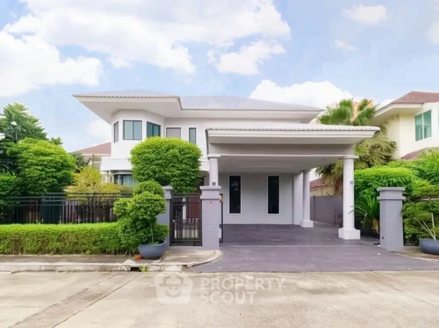 Elegant modern house with spacious driveway and lush greenery in a serene neighborhood.