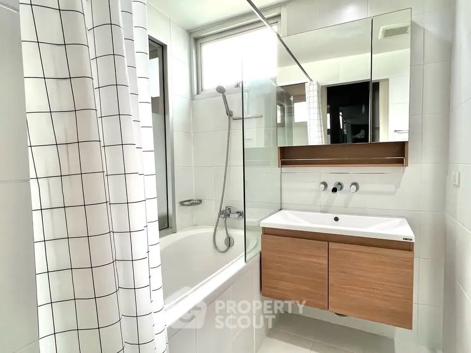 Modern bathroom with sleek fixtures and a bathtub in a contemporary apartment.