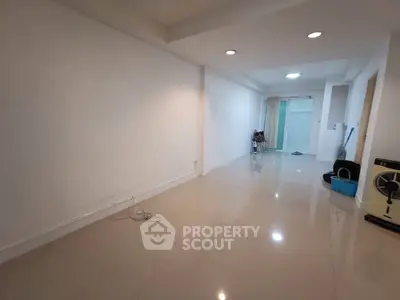 Spacious empty room with glossy tiled floor and recessed lighting