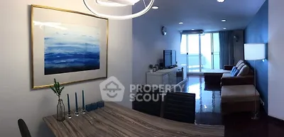 Spacious living room with modern decor and large windows leading to a balcony, perfect for relaxation.