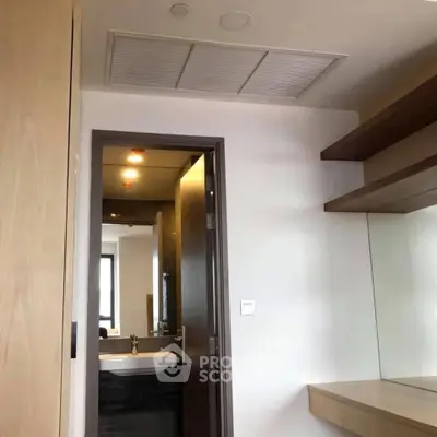 Modern interior with sleek bathroom entrance and stylish shelving, perfect for contemporary living.