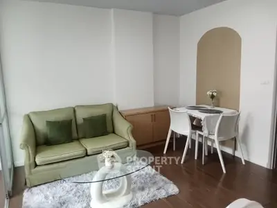 Charming living room with cozy green sofa and elegant dining area, perfect for modern living.