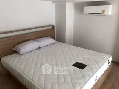 Modern bedroom with comfortable bed and air conditioning unit, perfect for restful nights.