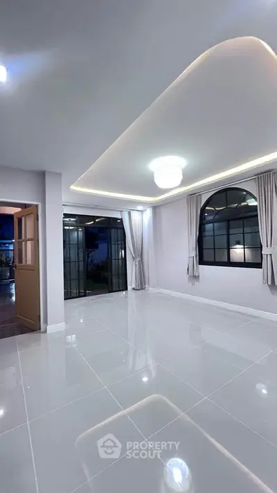 Spacious modern living room with elegant lighting and large windows.