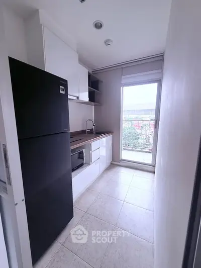 Modern compact kitchen with sleek appliances and balcony view