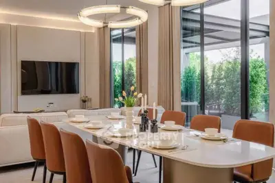 Luxurious dining area with elegant table setting and modern lighting in a spacious living room.