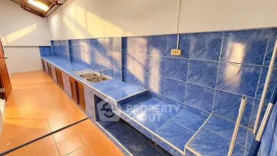 Spacious kitchen with vibrant blue tile countertops and ample storage space
