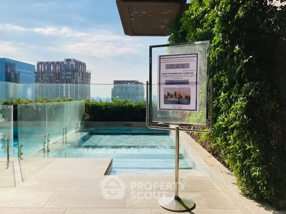 Luxurious rooftop pool with stunning city view and lush greenery, perfect for relaxation and leisure.