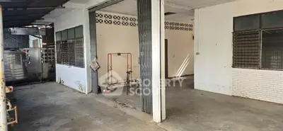 Spacious open garage area with potential for renovation in urban setting.