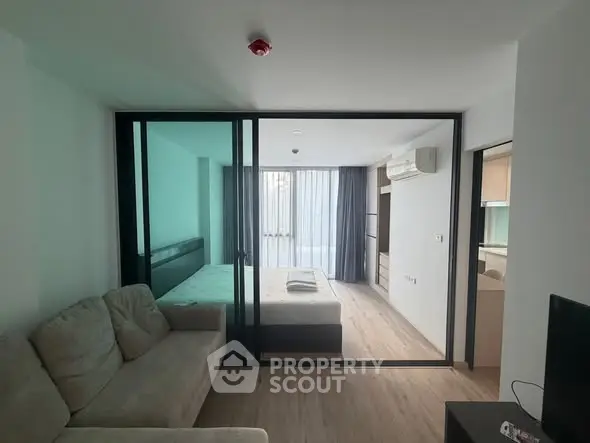 Modern studio apartment with glass partition and cozy furnishings