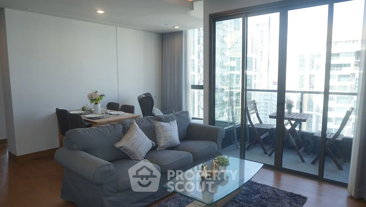 Spacious living room with modern decor and balcony view in high-rise apartment