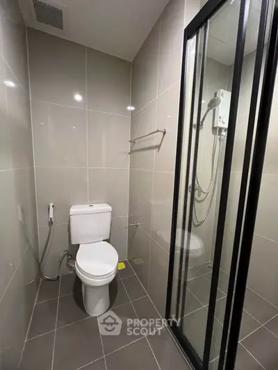 Modern bathroom with sleek shower and tiled walls in a contemporary apartment.