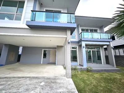Modern two-story house with glass balconies and spacious driveway